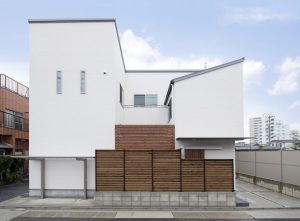 白に木目がアクセントになった個性的な家